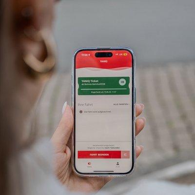Beispielbild der yaniq App auf einem Handy in der Hand einer Frau